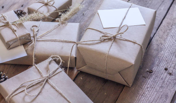 istock Christmas gift box Use brown recycled paper and notepad on a wooden table. 1293035556