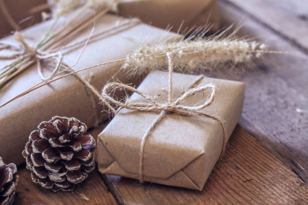 istock Christmas gift box Use brown recycled paper and notepad on a wooden table. 1293035560