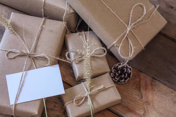 istock Christmas gift box Use brown recycled paper and notepad on a wooden table. 1293035562