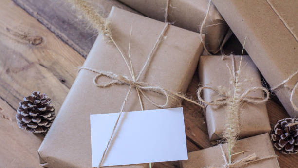 istock Christmas gift box Use brown recycled paper and notepad on a wooden table. 1293035563