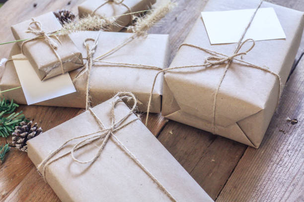 istock Christmas gift box Use brown recycled paper and notepad on a wooden table. 1293035565