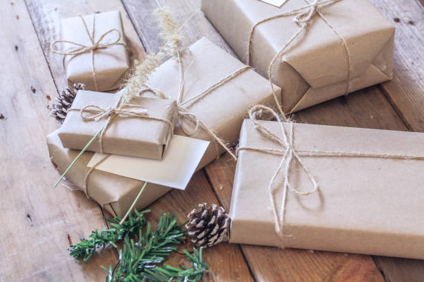 istock Christmas gift box Use brown recycled paper and notepad on a wooden table. 1293035569