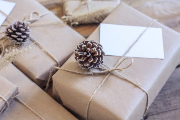 istock Christmas gift box Use brown recycled paper and notepad on a wooden table. 1293035570