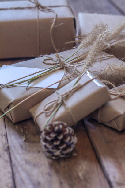 istock Christmas gift box Use brown recycled paper and notepad on a wooden table. 1293035571