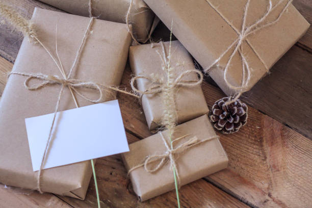 istock Christmas gift box Use brown recycled paper and notepad on a wooden table. 1293035575