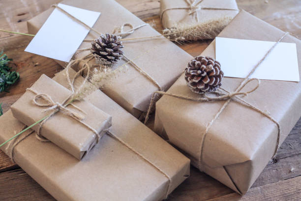 Christmas gift box Use brown recycled paper and notepad on a wooden table.