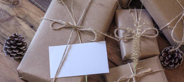 istock Christmas gift box Use brown recycled paper and notepad on a wooden table. 1293035585