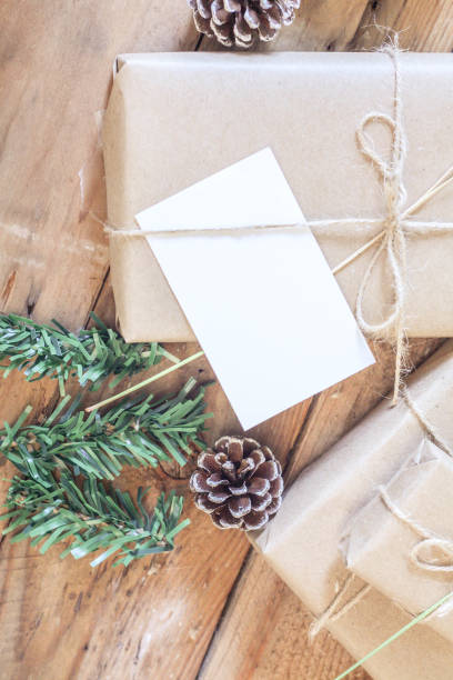 istock Christmas gift box Use brown recycled paper and notepad on a wooden table. 1293035590