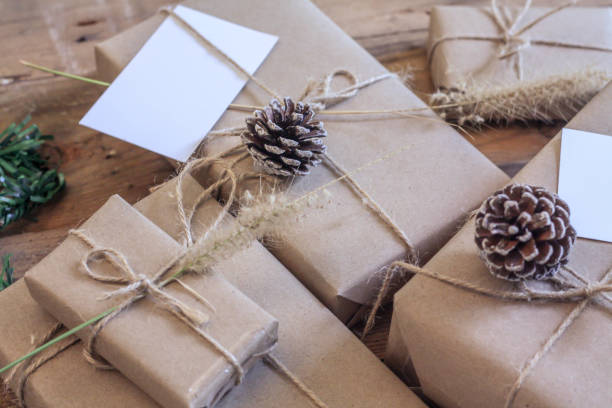 istock Christmas gift box Use brown recycled paper and notepad on a wooden table. 1293035594