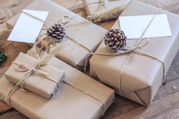 istock Christmas gift box Use brown recycled paper and notepad on a wooden table. 1293035596