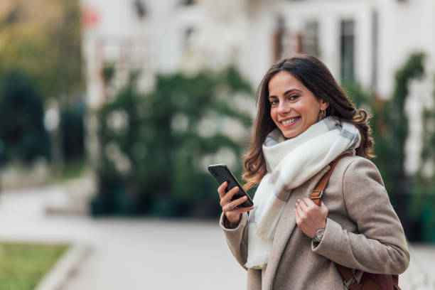 istock Girl using phone, wearing white scarf. 1293038893
