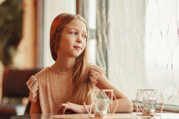 istock cute girl sitting at a table in a cafe 1293041435