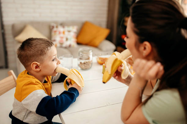 istock Mother and son eat a banana 1293043560