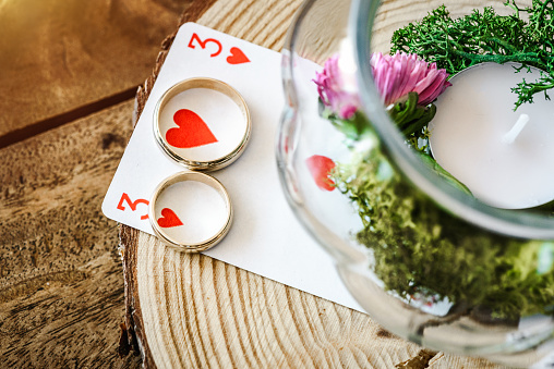 Two golden wedding rings on a hearts playing card stock photo. Wedding / decoration concept. Romantic / Romance concept.