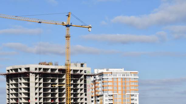 istock Build crane jib and unfinished skyscraper building with clouds in sky 1293046543