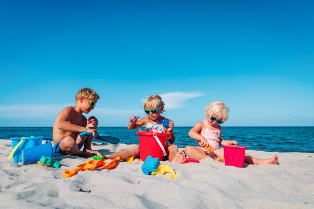 istock kids play with sand on beach vacation, boy and girls building sand castle 1293047607