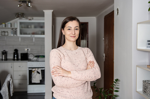 Portrait of smiling young woman at home looking at camera