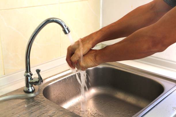 istock Young man washing his hands with tap water in the kitchen sink. Antivirus and avoiding coronavirus infection. 1293051204