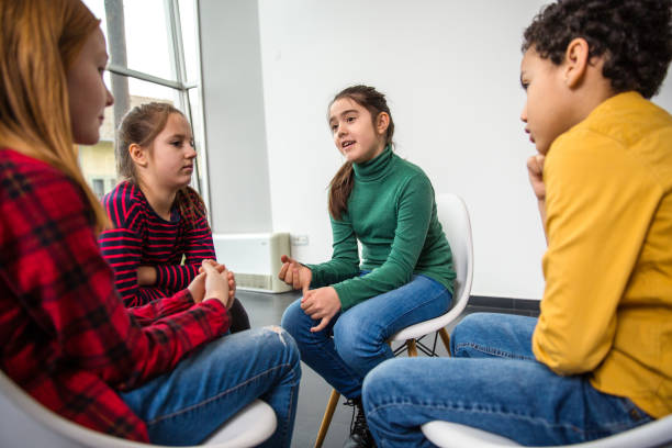 istock Group of children smiling and talking in a group session 1293054309