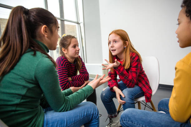 istock Group of children smiling and talking in a group session 1293054316