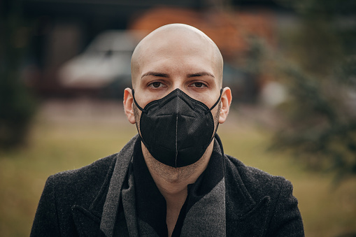 One man, portrait of modern young man wearing protective face mask in park.