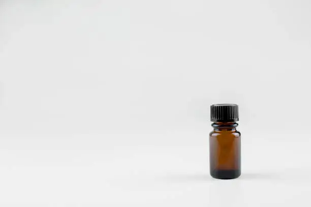 picture of small brown glass bottle for cosmetic preparations. Bottle on a light background.