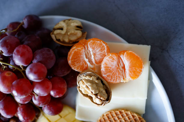 Istanbul, Turkey-December 24, 2020: Tangerine, Grapes And Nuts On The Breakfast Plate, Full Frame, Studio Shot, Flat lay.