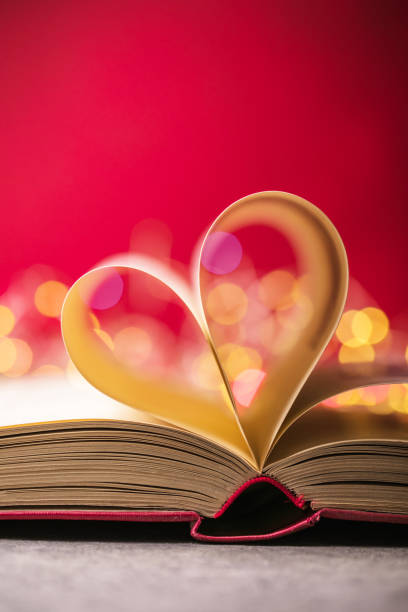 istock Book with love symbol on red background, heart shape from paper book. 1293058570