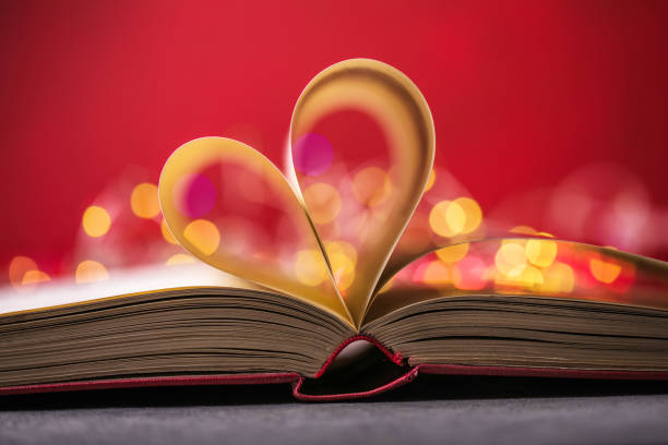 istock Book with love symbol on red background, heart shape from paper book. 1293058574