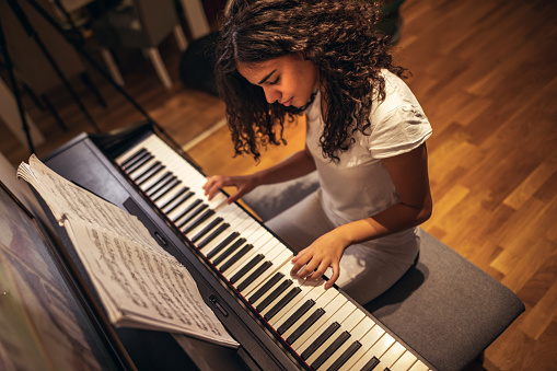 Girl learning to play piano during coronavirus pandemic