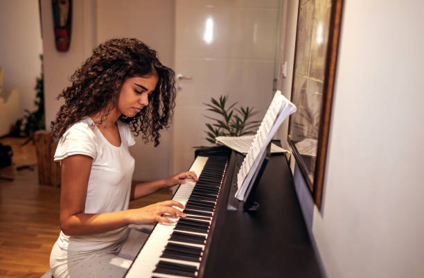 istock Girl playing piano at home 1293058714