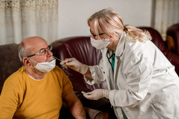 istock Nurse using a swab to take a sample from senior man's nose 1293062773
