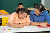 asiatische-autismus-kinder-mit-behinderung-kind-auf-rollstuhl-in-speziellen-klassenzimmer-mit.jpg?b=1&s=170x170&k=20&c=SIfhoqBLAUIx5npzLKDIvUpy53-OepkXip55EZ0O_qk=