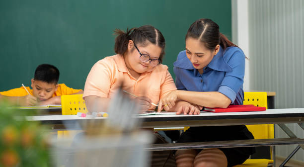Asian Autism children with disability kid on wheelchair in special classroom with teacher. Asian Autism children with disability kid on wheelchair in special classroom with teacher. developmental disability diversity stock pictures, royalty-free photos & images