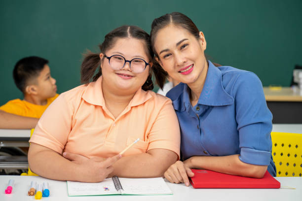 Asian Autism children with disability kid on wheelchair in special classroom with teacher. Asian Autism children with disability kid on wheelchair in special classroom with teacher. developmental disability stock pictures, royalty-free photos & images