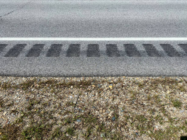 strisce di rombo fresco in strada di asfalto rurale che mostra striscia bianca e bordo di ciottoli di pietra - rumble strip foto e immagini stock