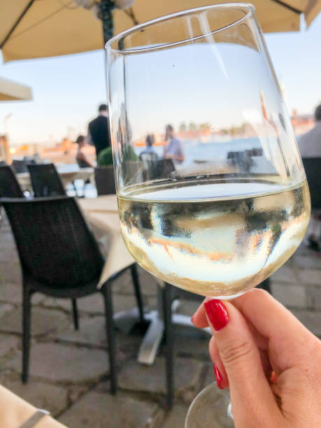 istock hand holding a glass of white wine 1293065637