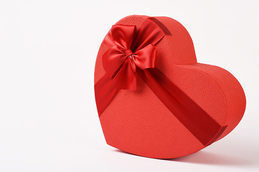 Red and gold different size heart shaped boxes with white, red and gold bows for Valentine's Day on a white background for gift
