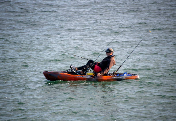 A kayak that uses pedal propulsion. A single man is using a pedal kayak for fishing.\nPort Canaveral, Florida\n12/19/2020