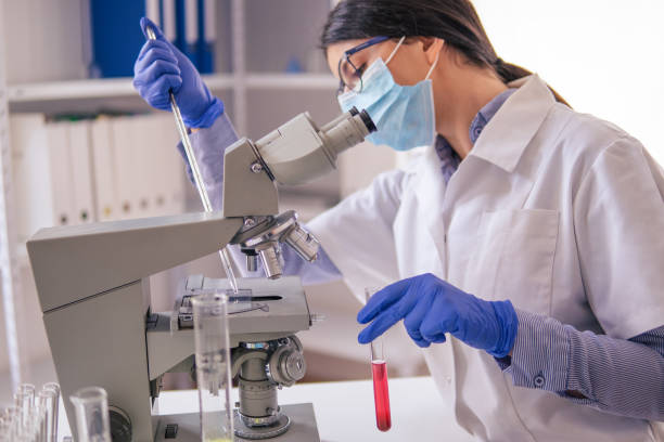 istock Coronavirus protection. Scientific researches in microbiological laboratory on COVID-19 vaccine elaboration in medical clinic. Female doctors wearing protective face masks looking at microbiology samples through a medical microscope and discussing. 1293066670