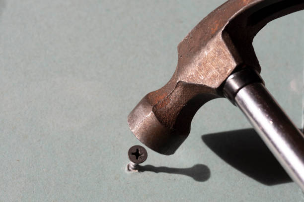 istock use a hammer to hammer the screw. Error in selecting the tool. 1293069034