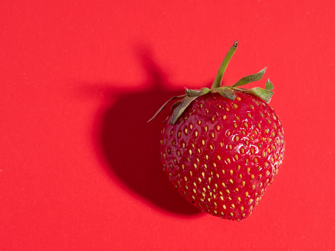 bright juicy ripe strawberries on a red background. Front view, healthy food, vegetarianism
