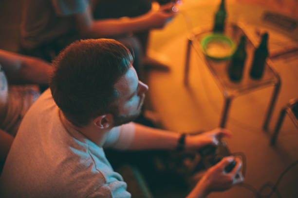 istock Young man playing video games at home 1293070901