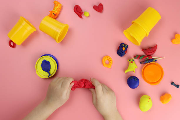 istock Child sculpts from colored plasticine on the table 1293074293