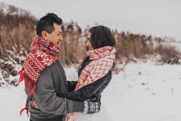 雪と冬にニットスカーフとミトンで愛のカップルの新郎新婦 - glove winter wool touching ストックフォトと画像