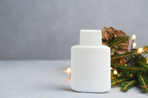 istock White cosmetics bottle and Christmas decoration on gray background. 1293082354