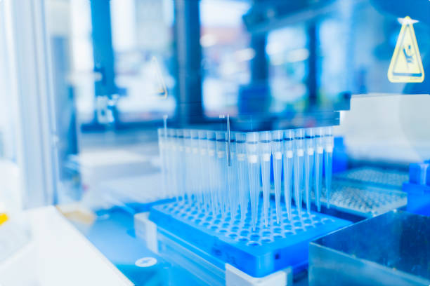 istock Robotics technology background. blue 96 well roboter head in genetics and medical laboratory. Medical diagnostics and research in futuristic fourth industrial revolution. 1293088236