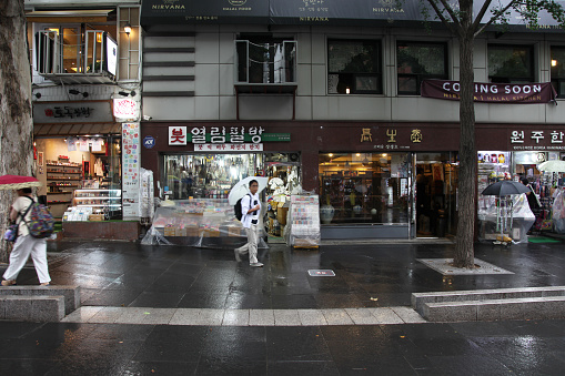 Seoul, South Korea - July 9, 2018. Insadong neighborhood in downtown Seoul. Shops and restaurants on Insadong street with shoppers walking in the rain.