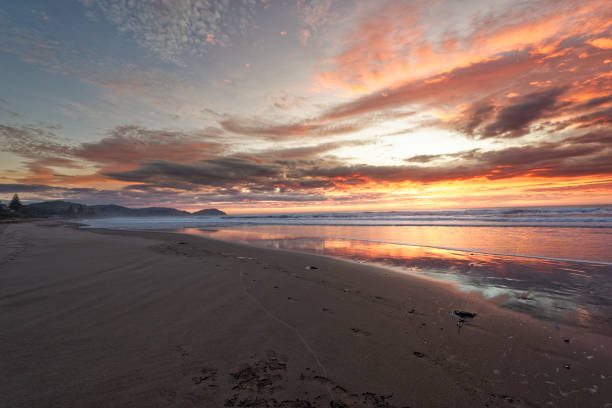 istock Golden sunrise across the ocean on a beach 1293090282