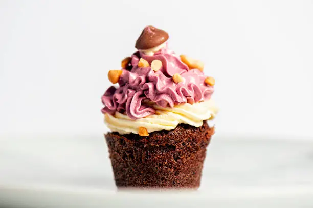 Chocolate cupcake with Swiss meringue buttercream, dessert food background.